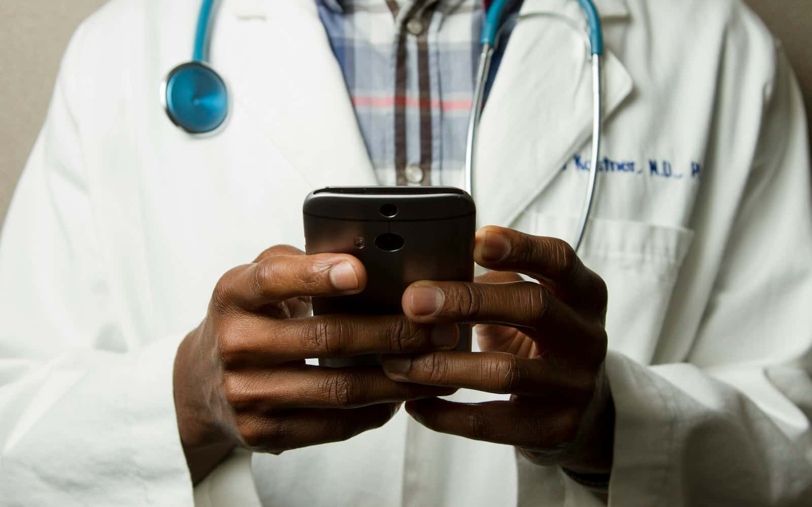 Elinde akıllı telefon tutan doktor