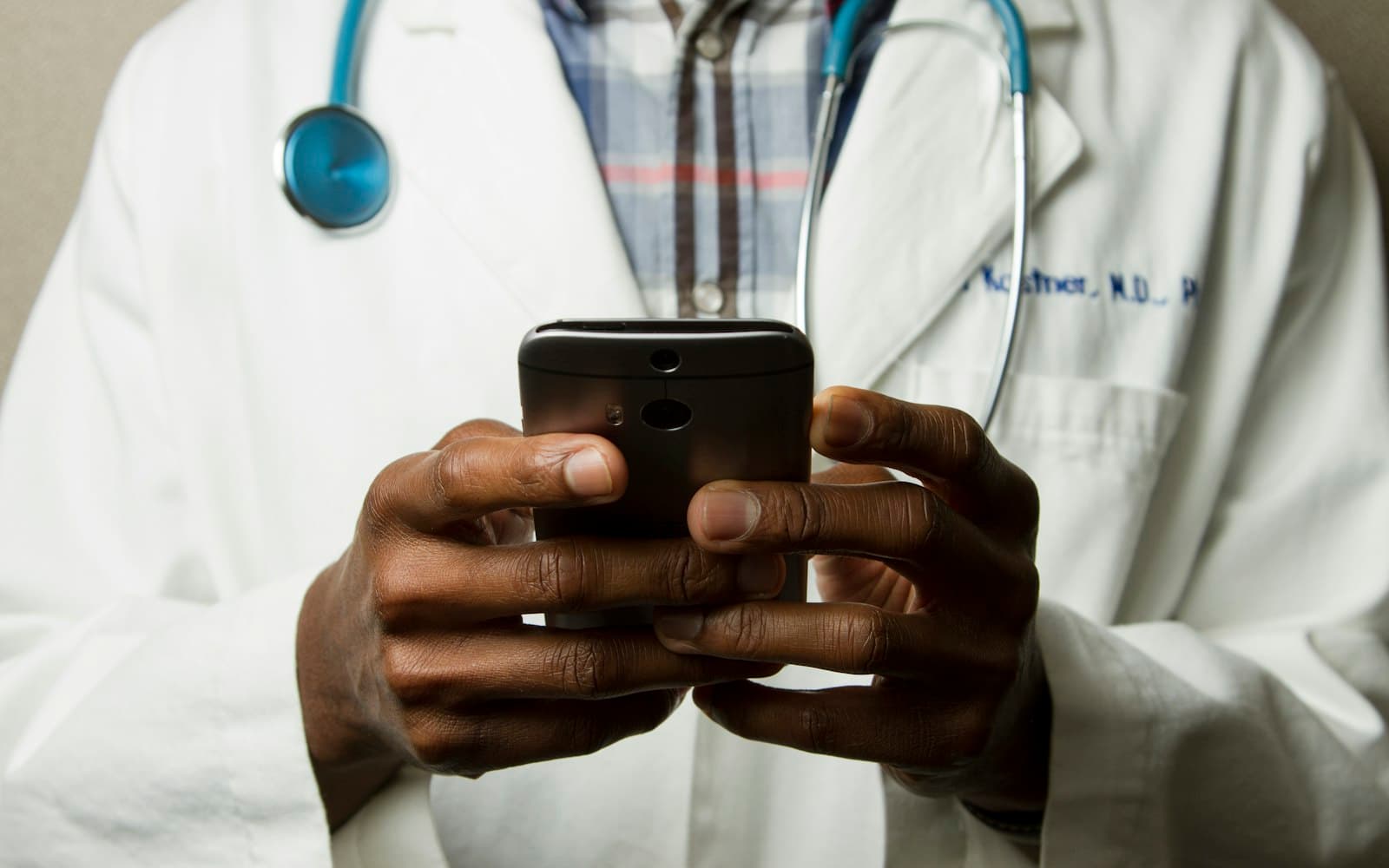 Elinde akıllı telefon tutan doktor