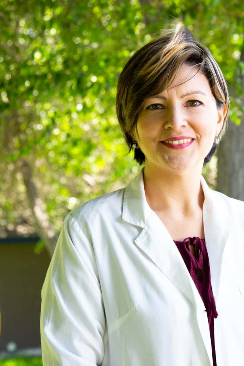 Beyaz önlüklü, gülümseyen kadın doktor
