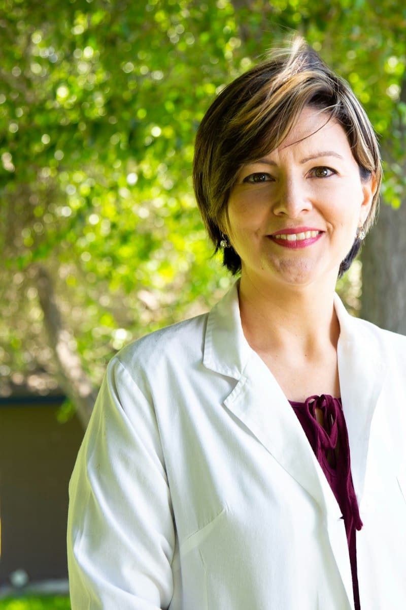 Beyaz önlüklü, gülümseyen kadın doktor